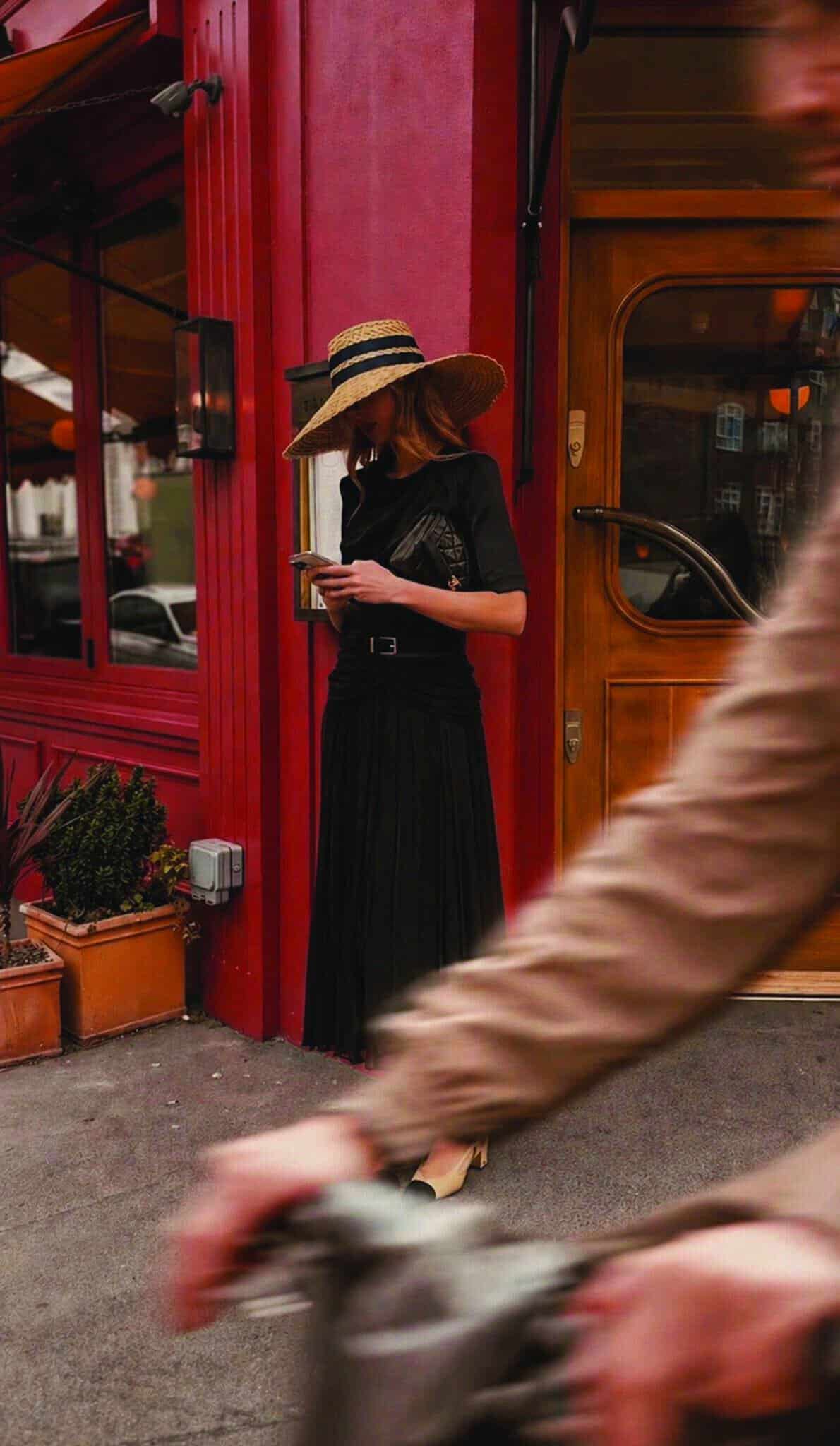 The Black Draped Skirt 3 A lady stood in front of a luxury womenswear boutique in a women's coord in London.