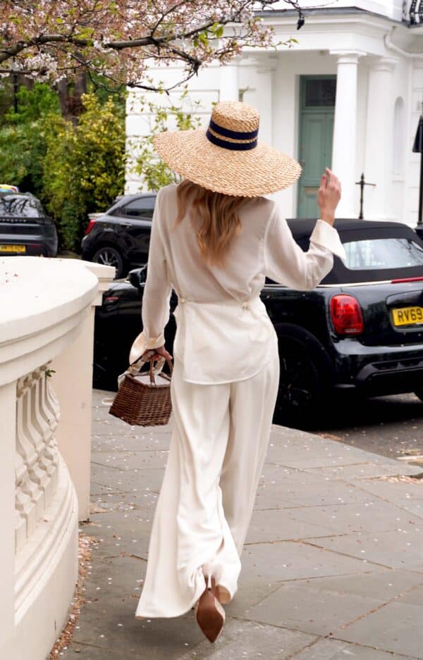 A lady stood outside of a luxury womenswear boutique in London.