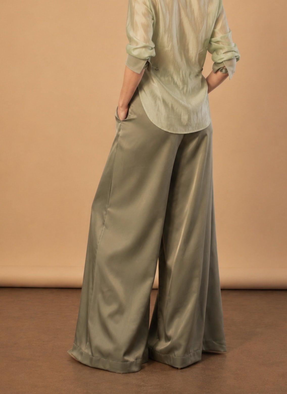Sage Pleated Palazzo Pant 8 Model wearing a satin tux shirt with wide-leg trousers for elegant style.