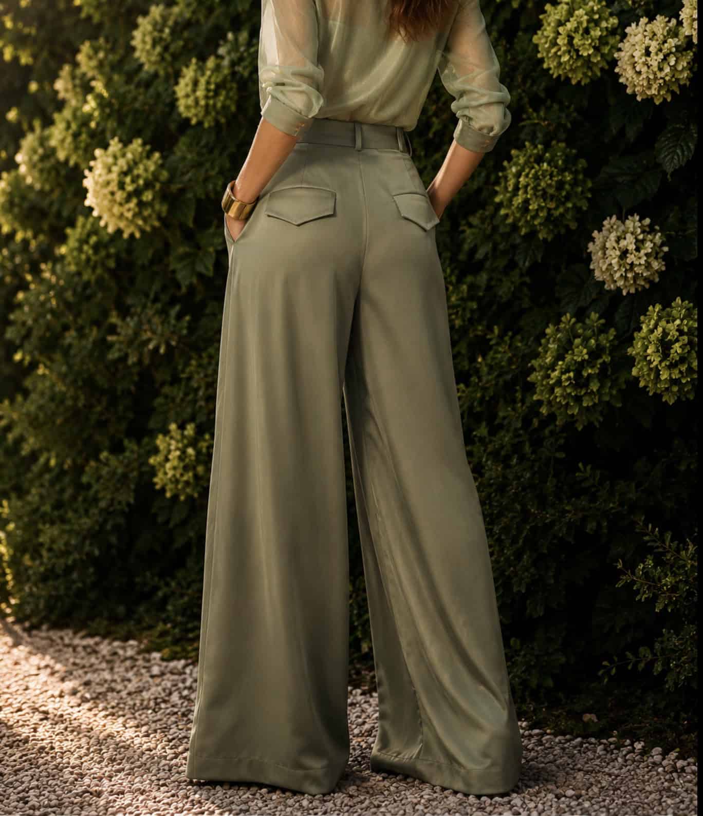 Sage Pleated Palazzo Pant 6 Woman wearing wide-leg trousers and a satin blouse outdoors.