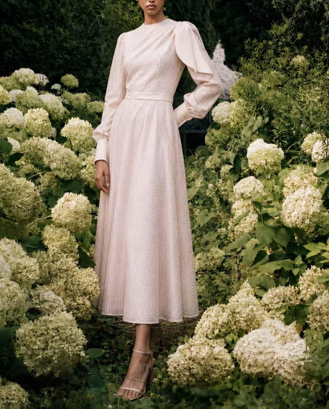 The Long-sleeved Catherine dress 3 Elegant long-sleeved dress by Aimee Joyce London in a garden setting.
