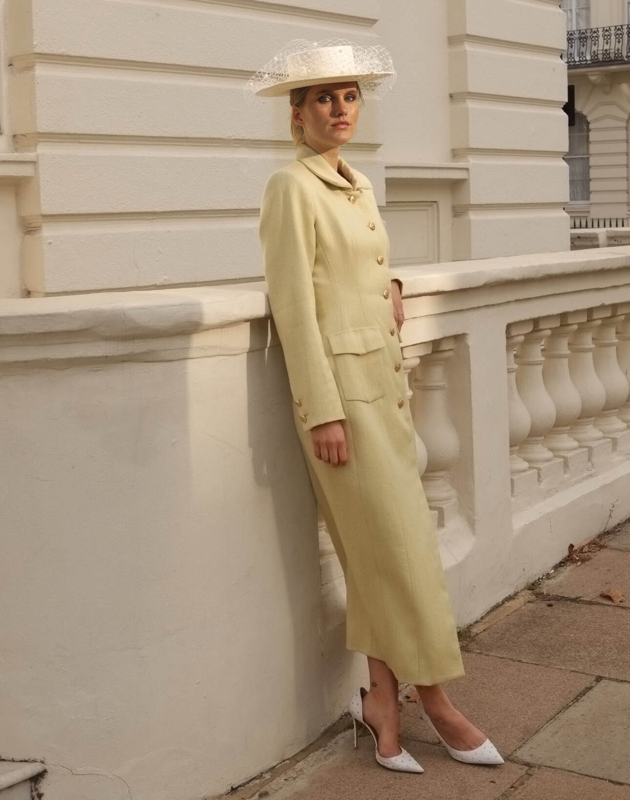 Pale yellow Celine coat styled with a white boater hat and pointed heels