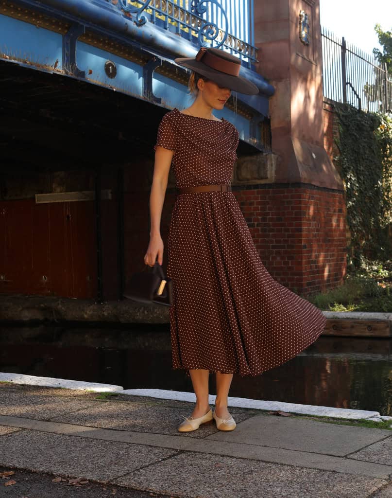 Penelope brown polka-dot dress with a brown Jane Taylor hat and Valentina handbag
