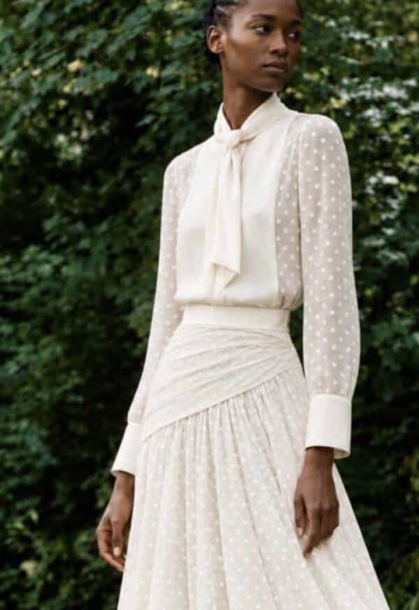 Close garden view of the white Gilda shirt, showing the Duchess satin neck tie, bib and cuffs with fine woven polka-dot cotton.