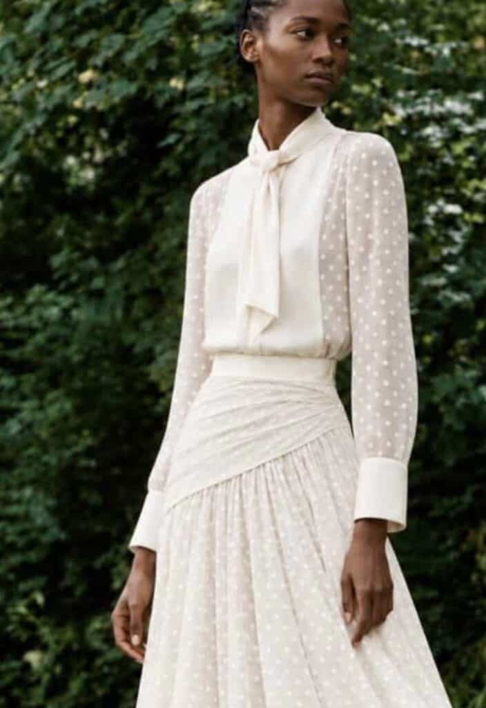 Close garden view of the white Gilda shirt, showing the Duchess satin neck tie, bib and cuffs with fine woven polka-dot cotton.